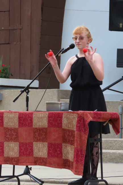 Youth performing a magic trick on stage.